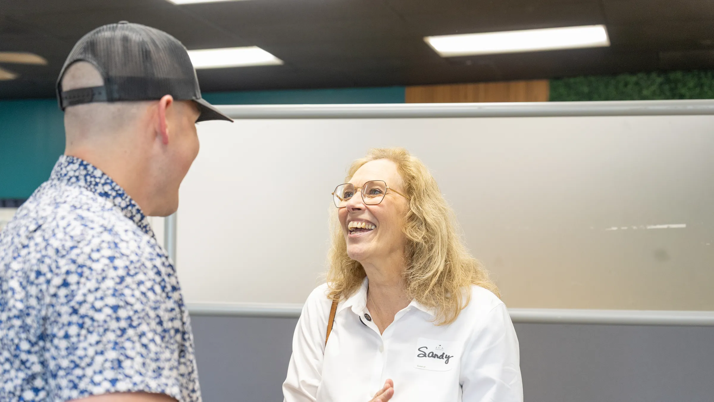 Aaron Wright talking with Sandy as she smiles at a New Life event